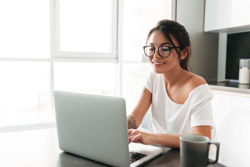 Estudiante sonriente utilizando laptop en LinkLingo